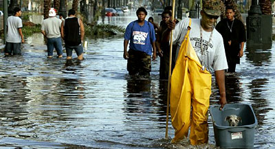 Hurricane Katrina survivors walk down a flooded street