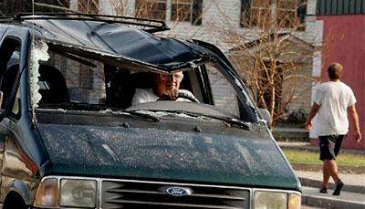 A Hurricane Katrina survivor drives his damaged van