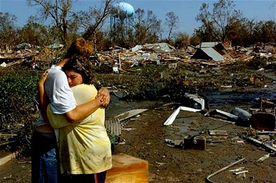 A couple embrace as they view their destroyed home