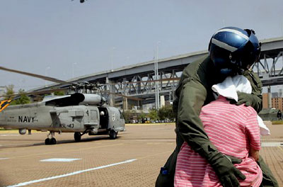 A Navy crewman comforts a distraught Hurricane Katrina survivor